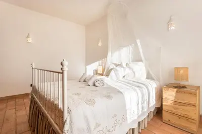 a white bed with a canopy in a bedroom at Casa da Ermida in Budens