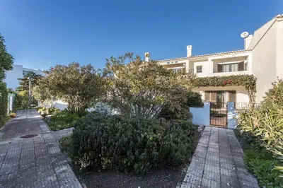 a house with trees and bushes next to a street at Casa da Ermida in Budens