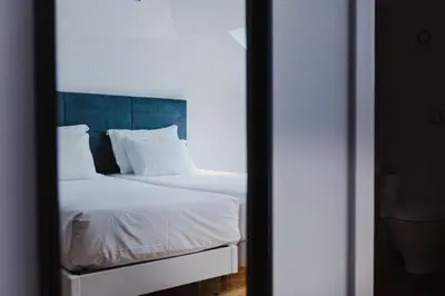 a bedroom with a bed with white sheets and pillows at Jaca Hostel Funchal in Funchal