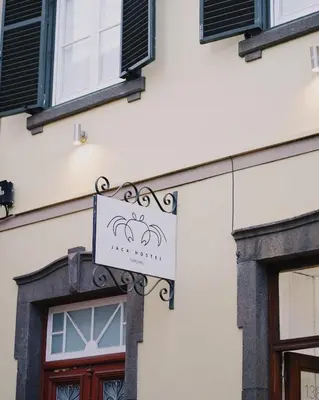 a sign hanging on the side of a building at Jaca Hostel Funchal in Funchal