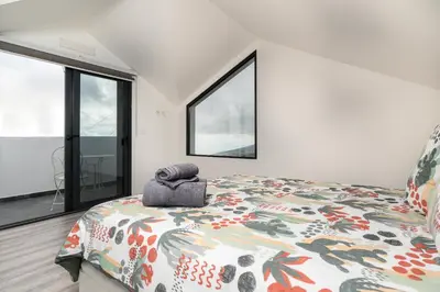 a bedroom with a bed and a large window at Casa Zé, in Arco da Calheta