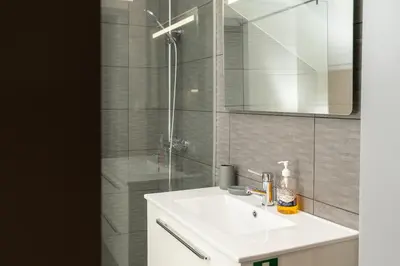a bathroom with a white sink and a shower at Casa Zé, in Arco da Calheta