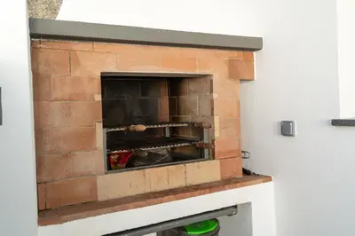 a brick oven in a room with a brick wall at Casa Zé, in Arco da Calheta