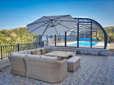a patio with a couch and a table and an umbrella at Casa Leão de Ouro by LovelyStay in São Jorge