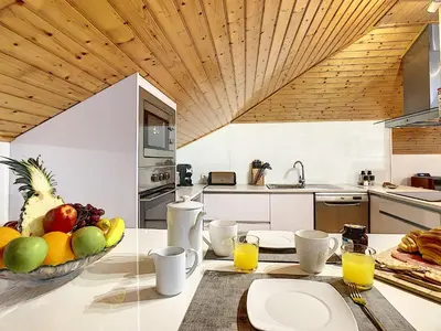 a kitchen with a bowl of fruit on a table at Casa Leão de Ouro by LovelyStay in São Jorge