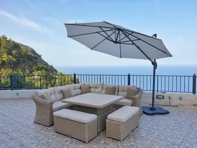 a patio with a table and an umbrella at Casa Leão de Ouro by LovelyStay in São Jorge