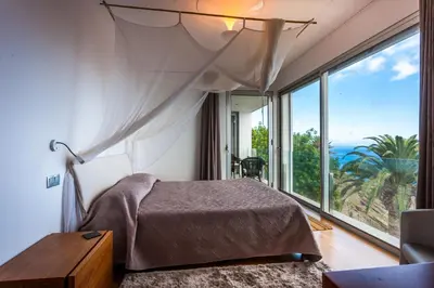 a bedroom with a bed and a large window at Casa Martinhos by LovelyStay in Caniço