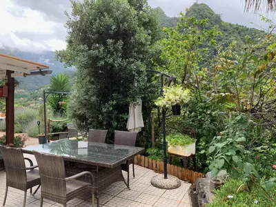 a patio with a glass table and a pergola at maderedocevida in Boaventura