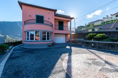 a pink house with a balcony on a hill at Cristina Grand in São Vicente