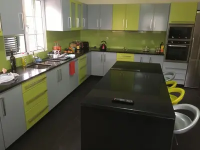 a kitchen with green and white cabinets and a black counter at Cristina Grand in São Vicente