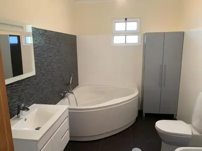 a bathroom with a tub and a toilet and a sink at Cristina Grand in São Vicente