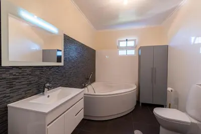 a bathroom with a tub and a sink and a toilet at Cristina Grand in São Vicente