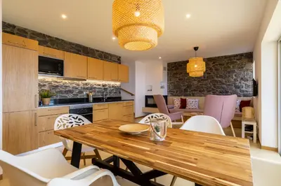 a kitchen and dining room with a wooden table and chairs at Villa Flora - Nature & Tranquility - Heated pool optional in Jardim do Mar