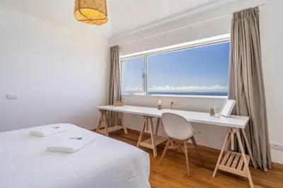 a room with a desk and a large window at Cantinho da Natureza - Nature & Tranquility - Heated pool optional in Jardim do Mar