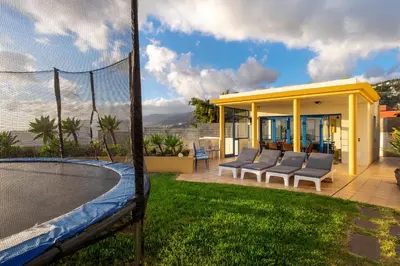 a tennis court with chairs and a net at Relax View in Funchal