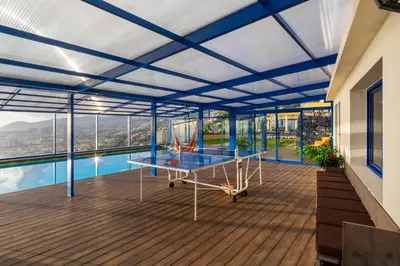 a room with a table on a deck with a pool at Relax View in Funchal