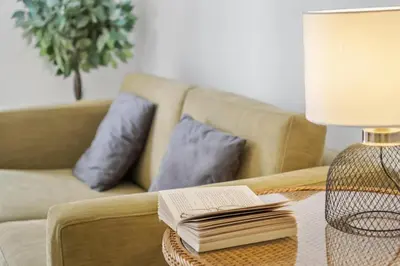 a living room with a table with a book and a lamp at Ribeira das Casas by Homie in Funchal