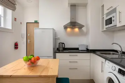a kitchen with a bowl of fruit on a wooden table at Ribeira das Casas by Homie in Funchal