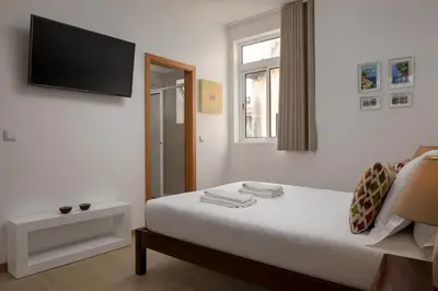 a bedroom with a bed with a flat screen tv on the wall at Ribeira das Casas by Homie in Funchal