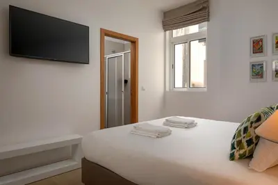 a bedroom with a bed with a flat screen tv on the wall at Ribeira das Casas by Homie in Funchal