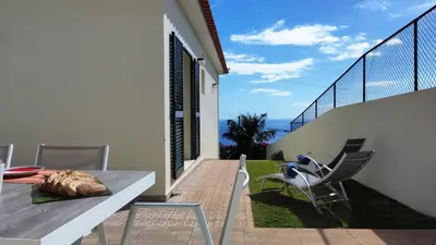 a patio with a table and chairs on a balcony at Casa Eleanor by LovelyStay in Calheta