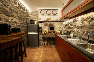 a kitchen with a refrigerator and a stone wall at Ga281 in Funchal