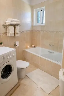 a bathroom with a toilet and a washing machine at Casadaluz 18 in Luz