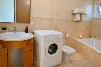a bathroom with a washing machine and a sink at Casadaluz 18 in Luz