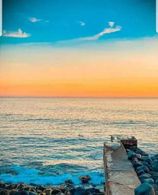 a pier on the water with the sunset in the background at O pomar - A quiet SUNNY place with amazing SEA views in Paul do Mar