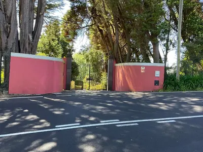 a red fence and a gate on a street at Quinta Das Faias in Camacha