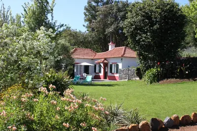 a small white house with a red roof at Quinta Das Faias in Camacha
