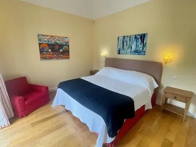 a bedroom with a bed and a red chair at Quinta Das Faias in Camacha