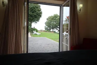 a bedroom with a door open to a yard at Quinta Das Faias in Camacha