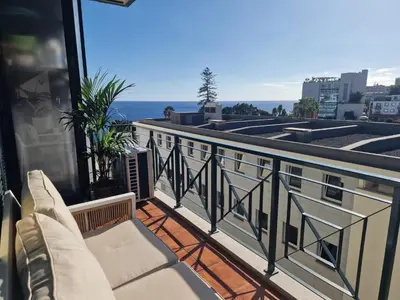 a balcony with chairs and a view of the ocean at Princesa Madeira in Funchal