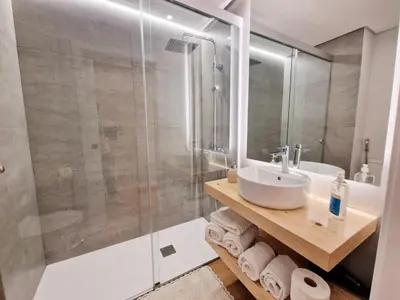 a bathroom with a sink and a glass shower at Princesa Madeira in Funchal