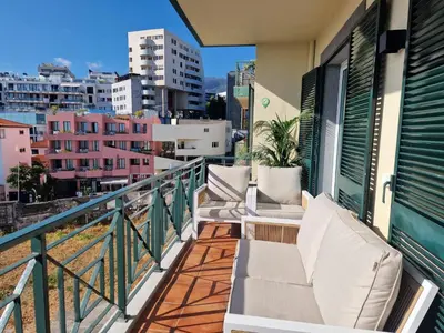 a balcony with chairs and a view of the city at Princesa Madeira in Funchal