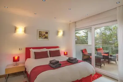 a bedroom with a large bed and a balcony at Casa Monte Cristo Too in Lagos