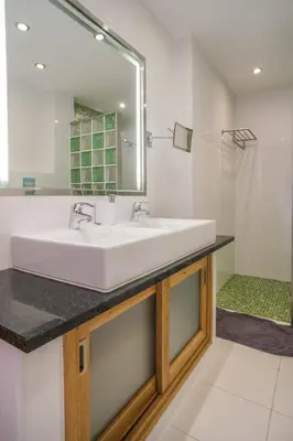 a bathroom with a white sink and a mirror at Casa Monte Cristo Too in Lagos