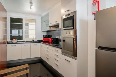 a kitchen with white cabinets and stainless steel appliances at Casa Skyline by An Island Apart in Caniço