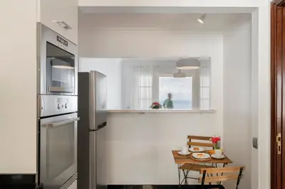 a kitchen with a table and a refrigerator at Casa Skyline by An Island Apart in Caniço