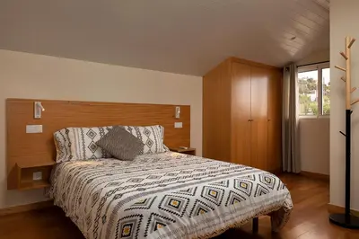 a bedroom with a large bed with a wooden headboard at Martinho Apartment View in Arco da Calheta