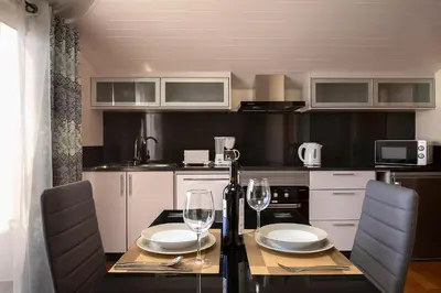 a kitchen with a table and two wine glasses at Martinho Apartment View in Arco da Calheta
