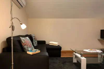 a living room with a black couch and a glass table at Martinho Apartment View in Arco da Calheta
