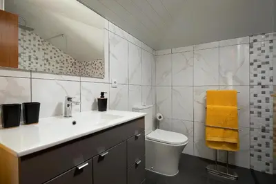 a bathroom with a sink and a toilet and a mirror at Martinho Apartment View in Arco da Calheta