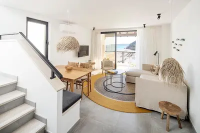 a white living room with a staircase and a living room at Casas da Praia by Sevencollection in Salema