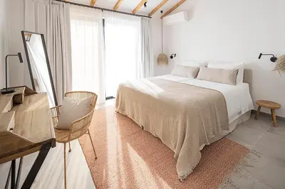 a white bedroom with a bed and a window at Casas da Praia by Sevencollection in Salema
