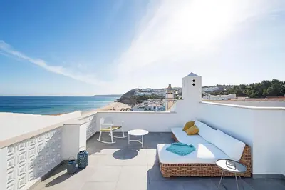 a balcony with a couch and a view of the ocean at Casas da Praia by Sevencollection in Salema