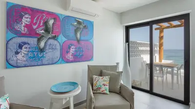 a living room with a couch and a painting on the wall at Casas da Praia by Sevencollection in Salema