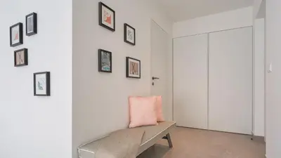 a white room with a bench and pictures on the wall at Casas da Praia by Sevencollection in Salema