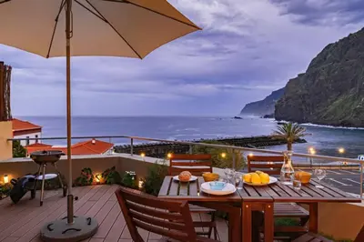 a table on a balcony with a view of the ocean at Ocean View in Ponta Delgada